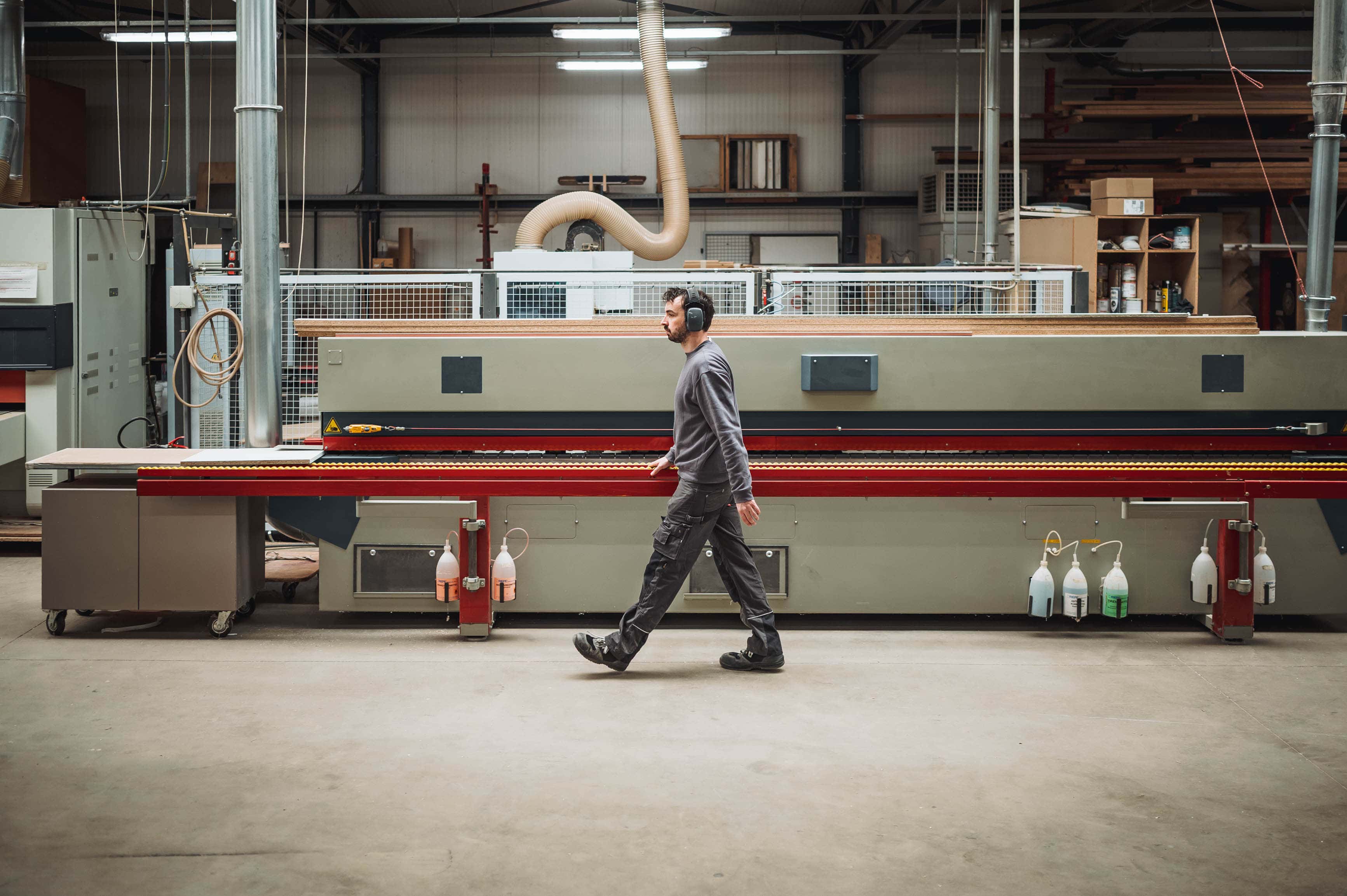 houtbewerker passeert machine in werkplaats — graffo fotografie