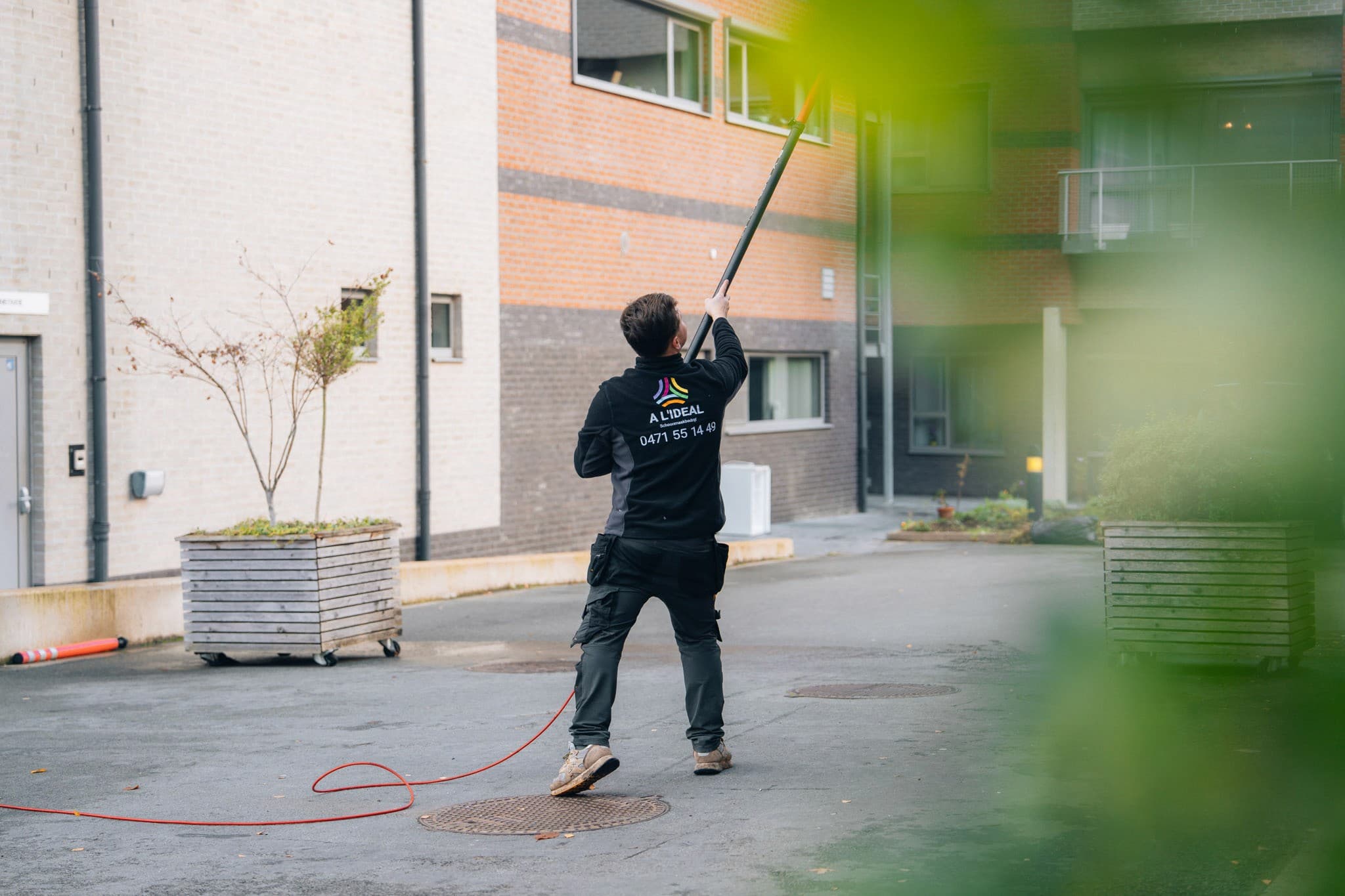 a l ideal, werker bij gevel — graffo fotografie